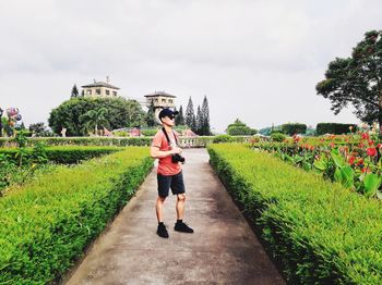 Full length of boy standing on grass against sky