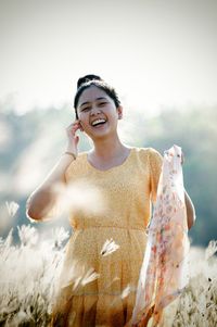 Portrait of smiling woman with scarf standing on field