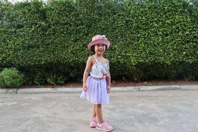 Full length of a girl standing against plants