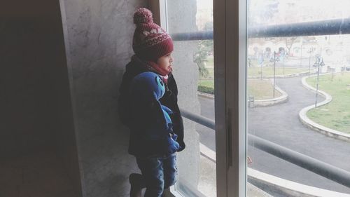 Side view of a woman looking through window