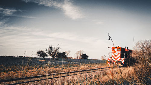 Railroad tracks on field against sky