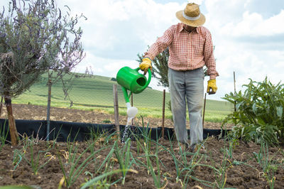 Full length of man standing in farm against sky