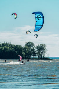 People enjoying in sea against sky