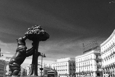 Low angle view of statue against buildings in city