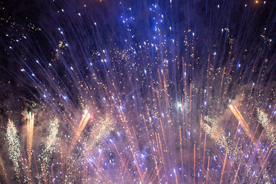 Low angle view of fireworks against sky at night