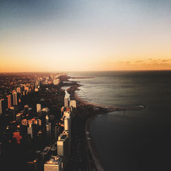 High angle view of sea and buildings against clear sky