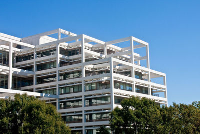 Low angle view of modern building against clear blue sky