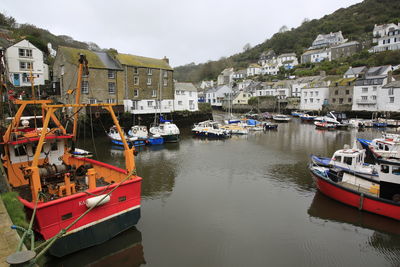 Boats moored at harbor by buildings in city
