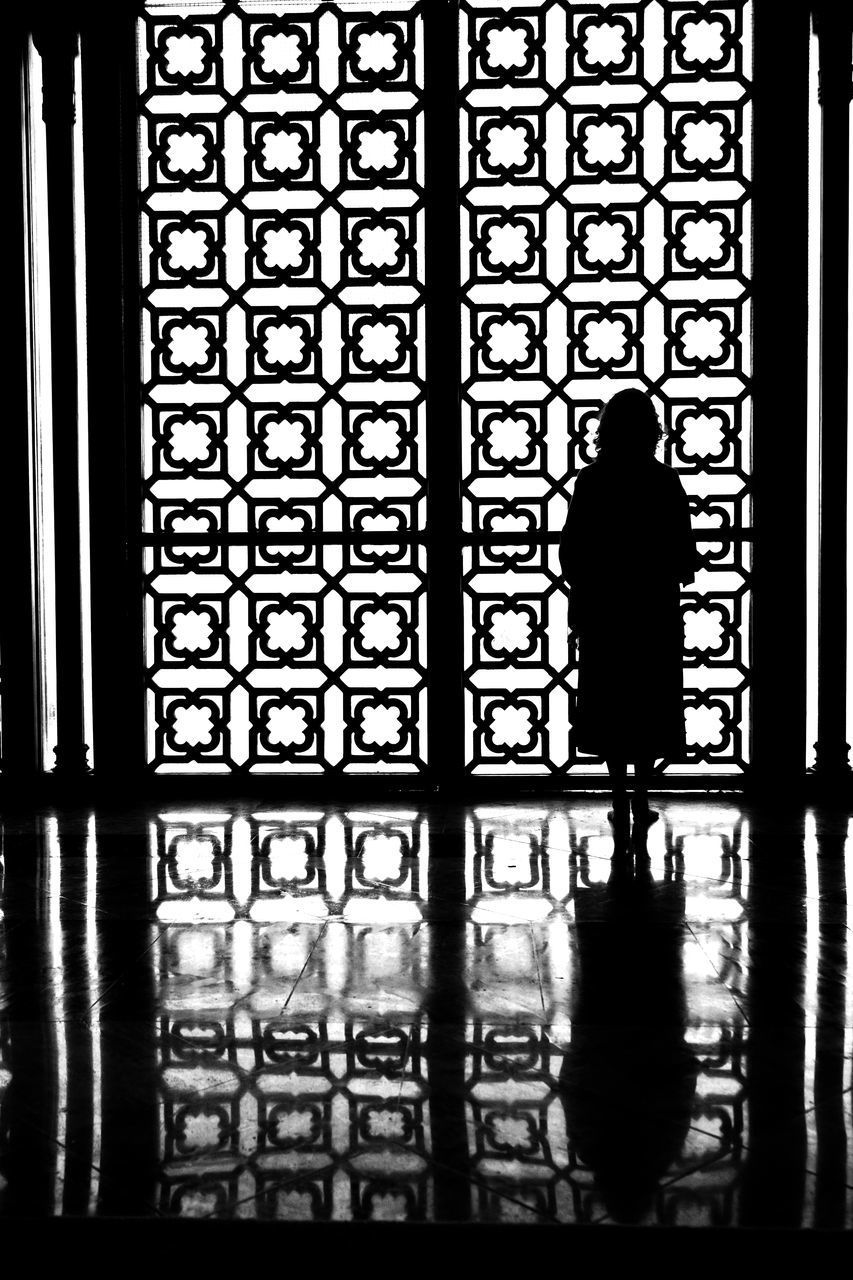 REAR VIEW OF SILHOUETTE WOMAN STANDING IN BUILDING