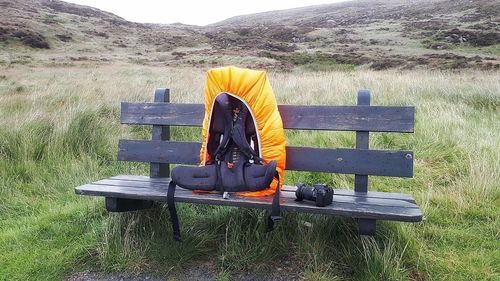 Man relaxing on bench in field