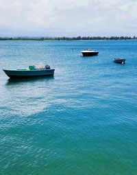 Boats sailing in sea against sky
