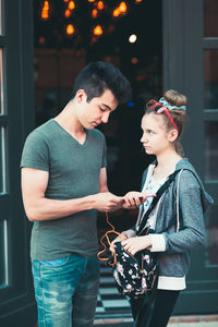 Young man with woman standing against the wall