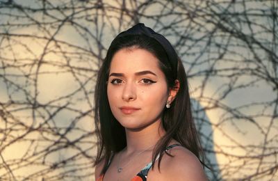 Portrait of beautiful young woman against wall