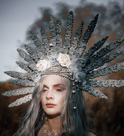 Beautiful woman wearing costume standing against trees