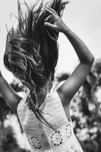 Rear view of girl tossing hair in park