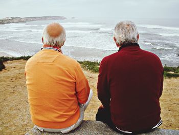 Rear view of people looking at sea shore