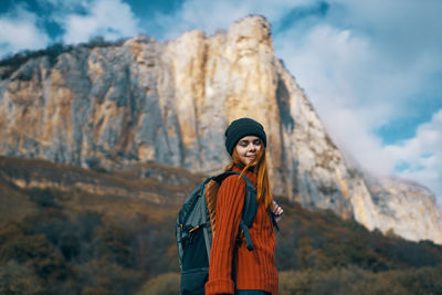 Young woman looking away while standing on mountain