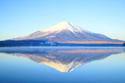 Scenic view of lake against clear blue sky