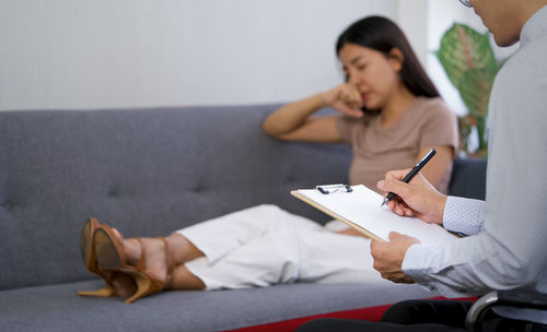 Young couple sitting on book at home