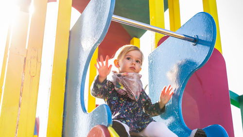 Low angle view of girl on multi colored playground