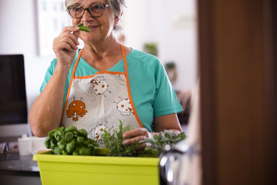 Midsection of woman holding ice cream at home