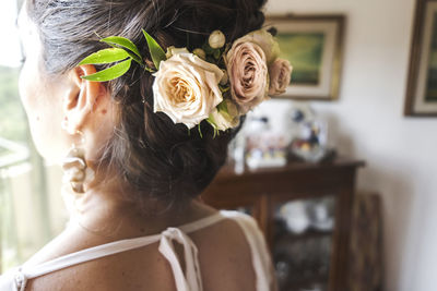 Close-up portrait of woman by rose at home