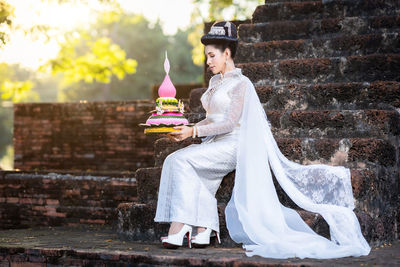 Side view of woman standing against wall