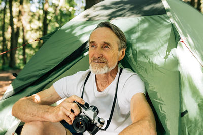 Portrait of senior man photographing with camera