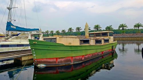 Boats moored in lake against sky
