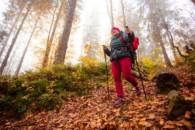 Full length of woman amidst trees in forest