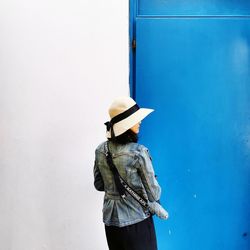 Rear view of woman standing against wall