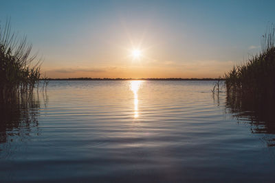 Scenic view of lake against sky during sunset