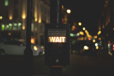 Close-up of illuminated equipment on pole at night