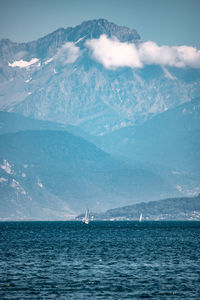 Scenic view of sea and mountains against sky