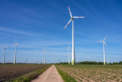 Modern wind turbines and a small country road seen in germany