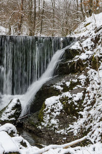 Scenic view of waterfall in forest during winter