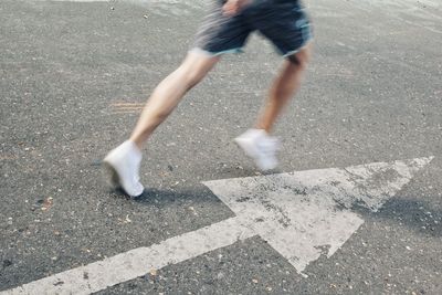 Low section of man running on road