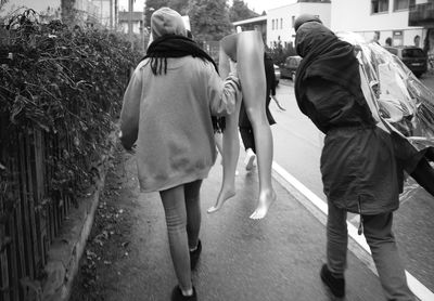 Rear view of people walking on street