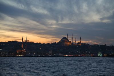 View of city at waterfront during sunset