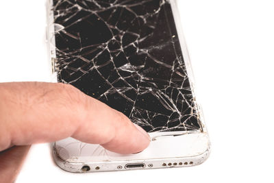 Close-up of hand holding camera over white background