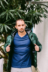 Portrait of man standing against plant