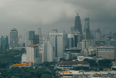 Aerial view of buildings in city against sky