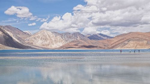 Scenic view of lake by mountains against sky