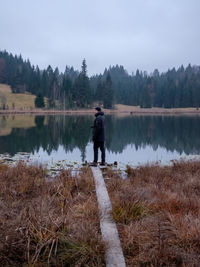 Man standing by lake against sky