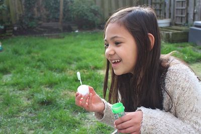 Close-up of smiling young woman holding ice cream in park