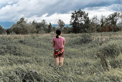 Rear view of woman walking on field