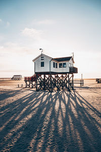 Lifeguard hut on beach by sea against sky