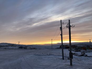 Scenic view of snow covered field against sky during sunset