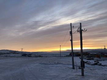 Scenic view of snow covered field against sky during sunset