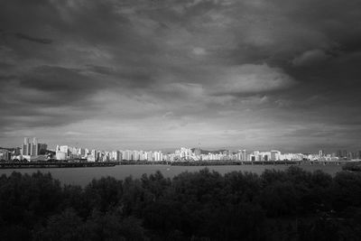 Buildings in city against cloudy sky